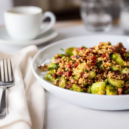 Plate of Brussels sprouts on a table with a cup and glass.